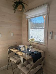 a dining room with a table and chairs and a window at Field and Fern Cottages in Tatamagouche