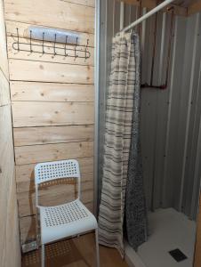 a sauna with a white chair and a wall at Field and Fern Cottages in Tatamagouche