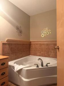 a bath tub in a bathroom with a sink at Auberge MicKy Inc in Edmundston +169 photos