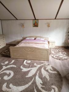 a bedroom with a bed and a large rug at Котедж Тиша in Rivnya