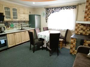 a kitchen with a table and chairs and a window at Котедж Тиша in Rivnya