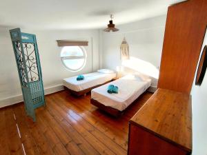 a bedroom with two beds and a window at Psalidi beach loft house in Psalidi