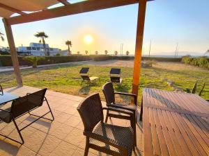 a patio with chairs and a table with the sunset at Psalidi beach loft house in Psalidi