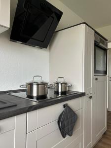 two pots on a stove in a kitchen at Michaels Elbtraum in Drochtersen