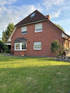 a red brick house with a grass yard at Michaels Elbtraum in Drochtersen