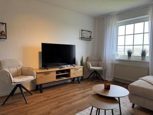 a living room with a flat screen tv on a wooden entertainment center at Michaels Elbtraum in Drochtersen