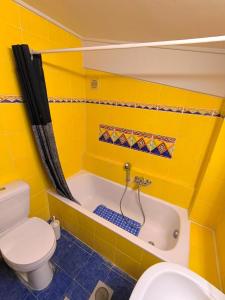 a yellow bathroom with a toilet and a tub at Psalidi beach loft house in Psalidi +53 photos