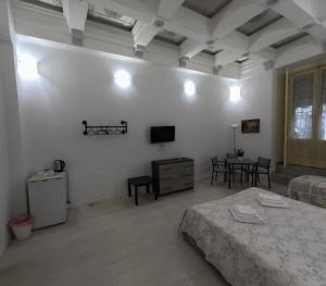 ein weißes Zimmer mit einem Bett und einem Tisch in der Unterkunft Hotel Gorizia in Catania