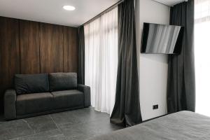 a bedroom with a couch next to a window at Relax Resort in Reshetilovskiy Kut