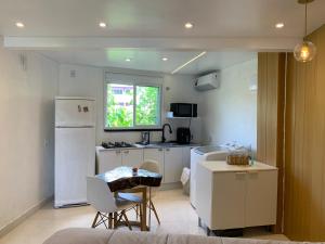 a kitchen with a white refrigerator and a table and chairs at Conchas Lofty in Governador Celso Ramos