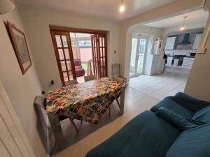 a dining room with a table and a couch at Fenia Estate in Barking