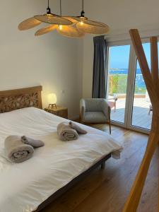 a bedroom with a large white bed with a window at Villa Solanella in Coti-Chiavari +48 photos