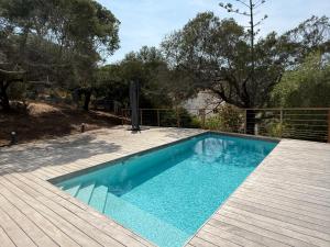a pool with a wooden deck and a swimming pool at Villa Solanella in Coti-Chiavari