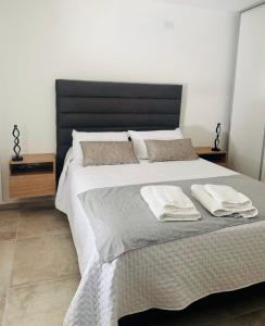 a bedroom with a large bed with two pillows at AF-Homes-Villa María in Villa María