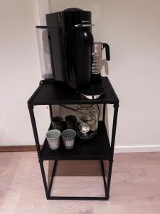 a black stand with a coffee maker and cups on it at Modern Flat In Flateby, Enebakk in Flateby