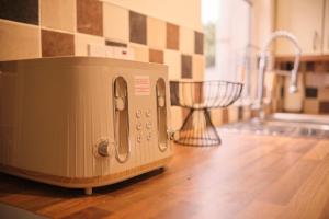 a toaster sitting on a counter in a kitchen at 2 Bedroom House By Travel Lets Holiday Homes Derry With Garden in Derry Londonderry