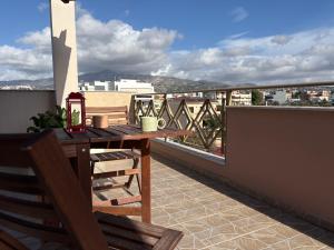 a wooden table on a balcony with a view at Purerest Entire Private Villa in Athens