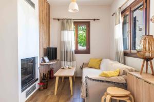 a living room with a couch and a tv at Petrichor houses in Portaria