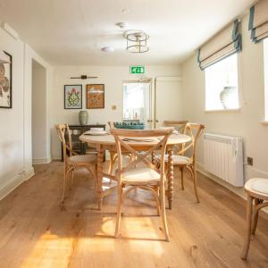 a dining room with a wooden table and chairs at Luxurious Town Centre Apartments in Cirencester