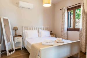 a bedroom with a white bed and a window at Petrichor houses in Portaria