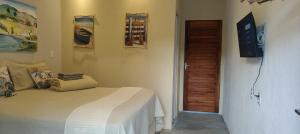 a bedroom with a bed and a wooden door at Vila Pescador Fortim in Fortim