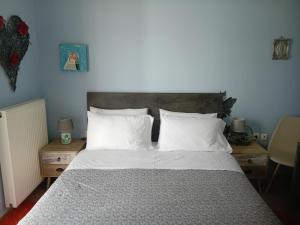 a bedroom with a large bed with white pillows at Ligeia Bedrooms Nafplio in Nafplio