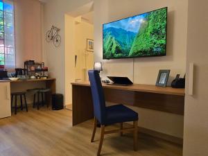 a room with a desk with a television on a wall at Residence Casa del Moro in Minerbio