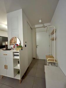 a white kitchen with a sink and a chair at Chambre privée chez habitant à Sète in Sète