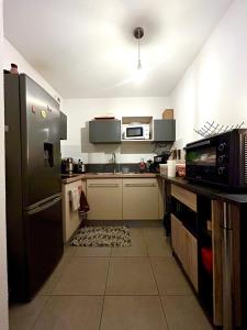 a kitchen with a black refrigerator and a microwave at Chambre privée chez habitant à Sète in Sète +8 photos