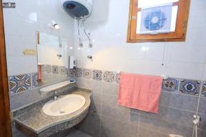 a bathroom with a sink and a mirror and a towel at Nefertari Palace apartments in Al Aqālitah +18 photos