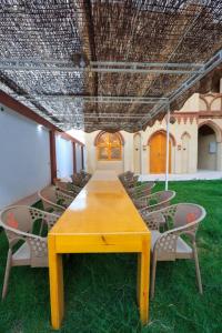 a yellow table and chairs in a room at Nefertari Palace apartments in Al Aqālitah