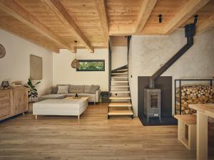 a living room with a staircase and a fireplace at Chalet Plechovka in Frýdštejn