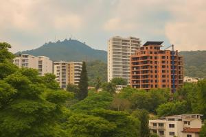 a group of buildings in a city with trees at Riviera Hotel Boutique in Cali