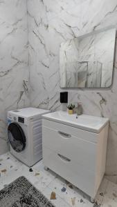 a white bathroom with a washing machine and a mirror at Villa Dacha in Izmail