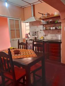 a kitchen with a table with chairs and a stove at Casa Ayres de la Quebrada in Humahuaca
