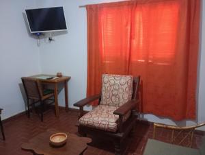 a room with a chair and a desk and a television at Casa Ayres de la Quebrada in Humahuaca