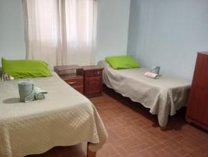 two beds in a room with green pillows at Casa Ayres de la Quebrada in Humahuaca +11 photos