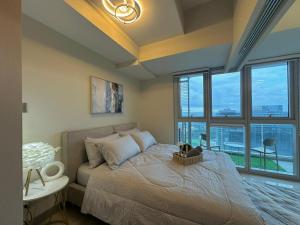 a bedroom with a large bed with a large window at 35th Prime Staycation BGC in Manila +6 photos