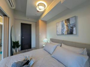 a bedroom with a large bed with white pillows at 35th Prime Staycation BGC in Manila