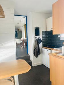 a kitchen with a refrigerator and a dining room at Charmante maison entre Marché et Tourelles in Pornichet +24 photos