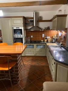 a kitchen with white cabinets and a wooden counter top at Prázdninový dům u Špičáku in Albrechtice v Jizerských horách