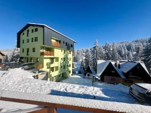 a building in the snow with a parking lot at SkyLux Vlašić in Šišava