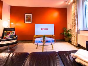a living room with a couch and a tv at Au Petit Pierrot in Spa +26 photos