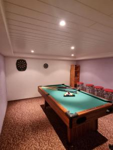 a pool table in a room with red chairs at Ferienhaus in Thüringen Nähe Hohenwarte Stausee in Unterwellenborn