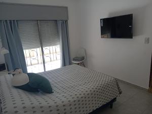 a bedroom with a bed and a large window at Casa Esmeralda in Concordia