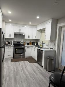 a kitchen with white cabinets and black appliances at J & J Dream Villa Ltd in Abbotsford