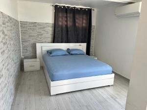 a bedroom with a bed with blue sheets and a window at Appartement Acajou Pool & Serenity in Le Lamentin +26 photos