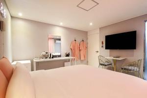 a hotel room with a bed and a television at MoMo Juice Busan Haeundae in Busan