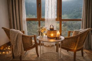 a table with a candle and two chairs in front of a window at Carbayu Senda del Oso in Proaza
