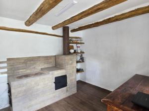 a brick fireplace in a room with wooden floors at Садиба У баби Христі in Shupiki